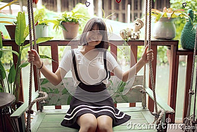 Asian teenager happiness on wood swing Stock Photo