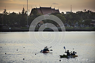 Asian thai people and foreign travelers playing and practice sports paddle boat canoe in pond in dusk time of Nong Prajak Editorial Stock Photo