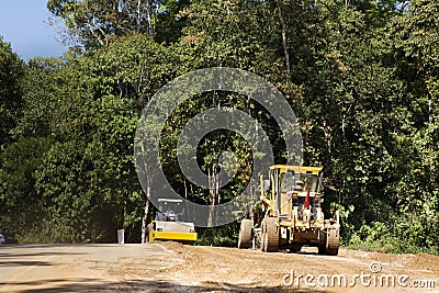 Thai workers use heavy machinery motor grade and vibratory roller working made and build road on mountain in Chiang Rai, Thailand Editorial Stock Photo