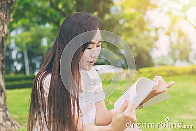 Asian thin teen relax reading in the green park Stock Photo