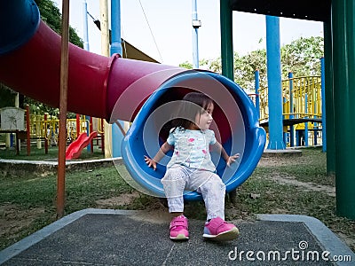 Asian toddler at the playground slide in the morning Stock Photo