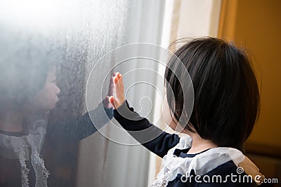 Asian toddler watching the snow Stock Photo