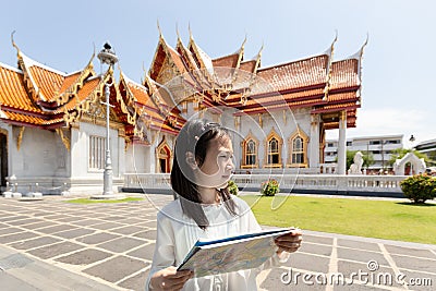 Asian tourist girl sightseeing holding map with big temple at Wa Stock Photo