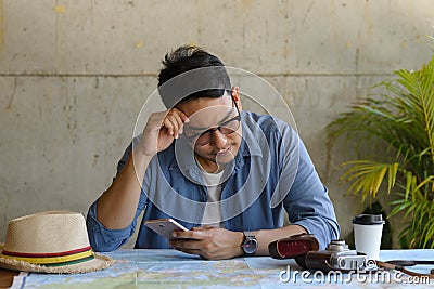 Asian tourist looking at worldmap and plans for his new trip Stock Photo