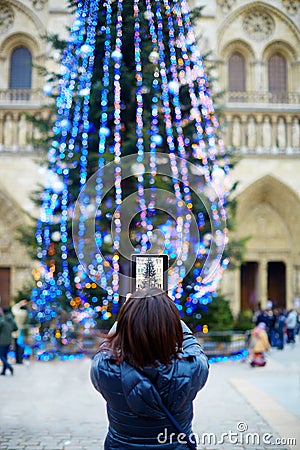 Asian tourist in Paris taking photo of Christmas tree Editorial Stock Photo