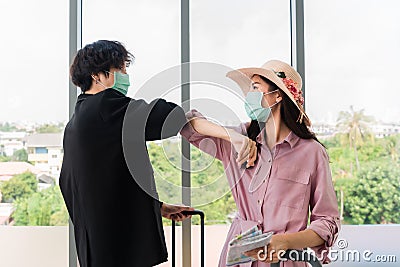 Asian tourist woman and man wearing protect hygiene mask for outbreak of coronavirus or covid 19 standing and greeting each other Stock Photo
