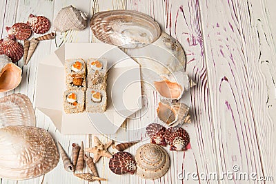 Asian traditional Ebi Tempura Sushi with black tiger shrimp, sesame seeds and red caviar on top in delivery takeaway box on wooden Stock Photo