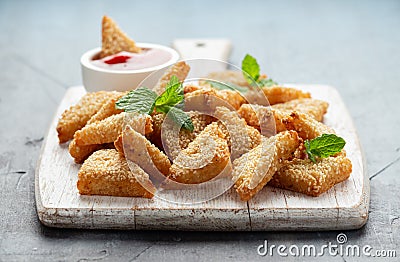 Asian Traditional Prawn Toast with Sesame seeds and sweet chilli sauce on wooden white board Stock Photo