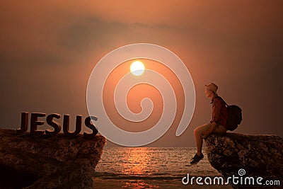 Asian traveler man with backpack sees Jesus text on the top of the hills Stock Photo