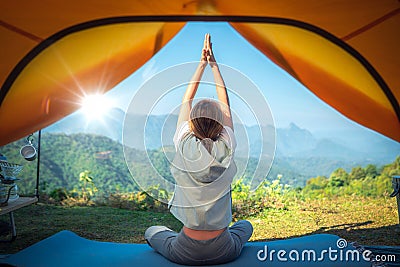 Asian traveller woman post yoga in tent on her camping Stock Photo