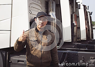 Asian A Truck Driver Looking and Giving Thumb-Up with Semi Truck. trucker. Transport and Logistics. Stock Photo