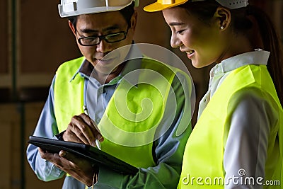 Asian warehouse manager discuss with worker Stock Photo