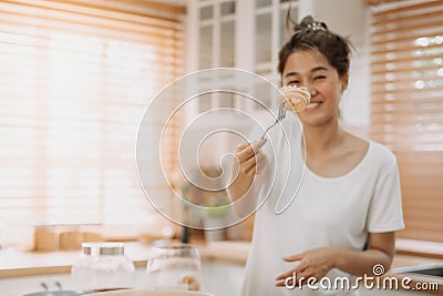 Wife cooking and prepare noodle meal for husband in the kitchen. Stock Photo