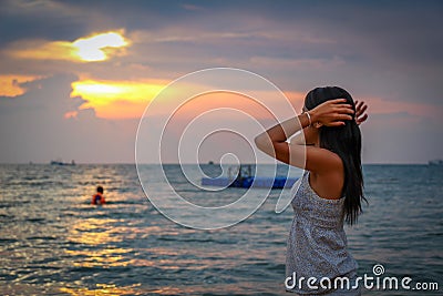 An Asian women admiring the sunset on Ba Keo Beach, Phu Quoc, Vietnam Stock Photo