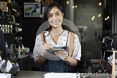 Asian women Barista smiling and using coffee machine in coffee s Stock Photo