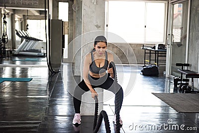 Asian woman battle rope exercise in gym Stock Photo