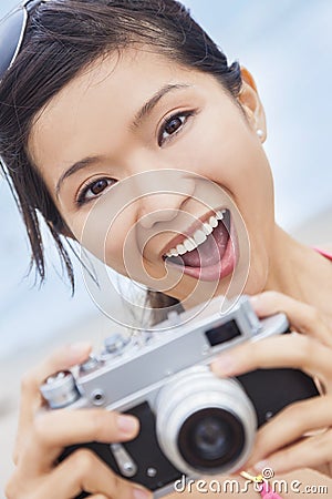Asian Woman at Beach Taking Photograph With Camera Stock Photo