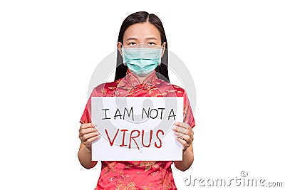 Asian woman in Chinese costume wear a hygienic mask holding sign I am not a VIRUS for anti racism , bullying and hate Stock Photo