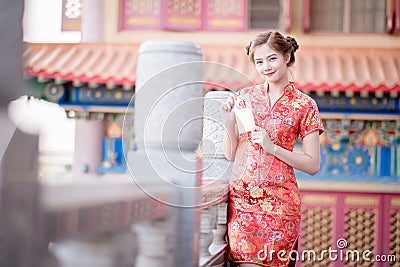 The Asian woman in chinese dress holding couplet 'Lucrative' (C Stock Photo