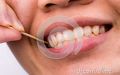 Asian woman clean her teeth from food stuck her teeth with bamboo wood toothpick after breakfast, lunch, dinner. Personal dental Stock Photo