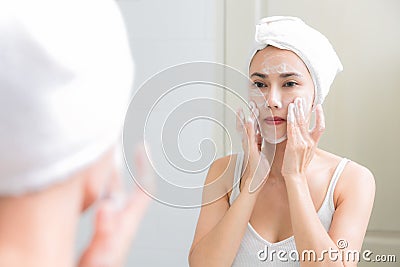 Asian woman cleaning face skin enjoy herself with bubble cleansing foam. Stock Photo