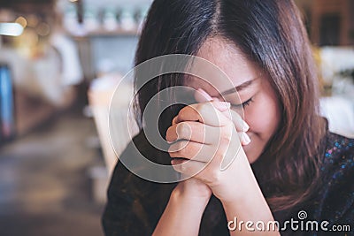 Asian woman close her eyes to praying and wishing for a good luck Stock Photo