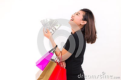 Asian woman with colorful shopping bags. One hand holds money one hundred dollar bill on white background. Stock Photo