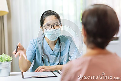 Asian Woman Doctor talking to female patient at the hospital Stock Photo