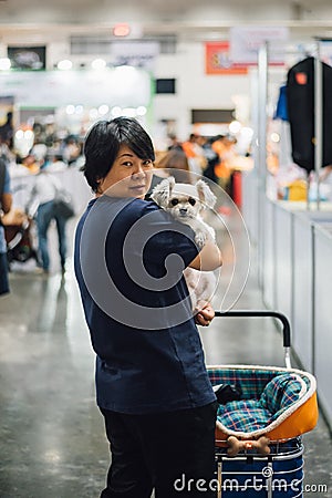 Asian woman and the dog in exhibit hall or expo Stock Photo