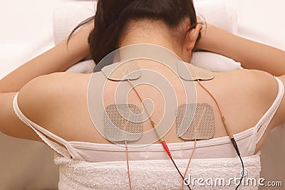 Asian woman is doing massage of electrical -stimulation ( TENs ) Stock Photo