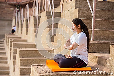 Asian Woman doing outdoor yoga tree pose meditation exercise, mental peace Editorial Stock Photo