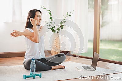 Asian woman doing yoga shoulder stretching online class at home Stock Photo