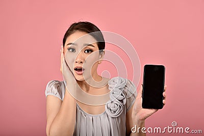 Asian woman with doubtful and questioning expression face holding smartphone. Stock Photo