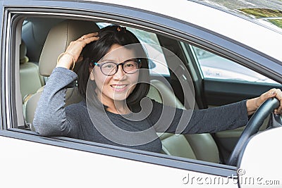 Asian woman driving car lookiing to camera with smiling face hap Stock Photo