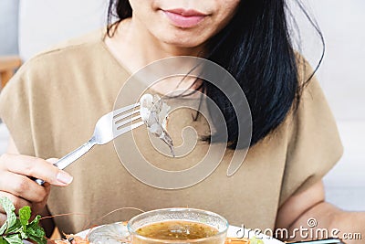 Asian woman eats raw shrimp, uncooked seafood , unhealthy eating concept Stock Photo