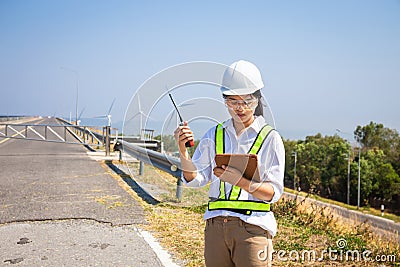 Asian woman engineers are using walkie-talkies and tablet outdoors on site power plant energy Stock Photo