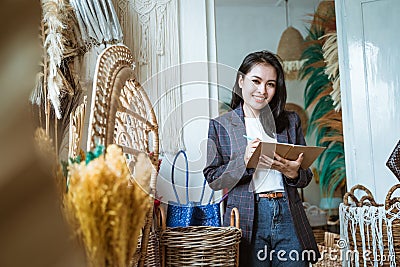 Asian woman entrepreneurs take notes on a handmade flower background Stock Photo