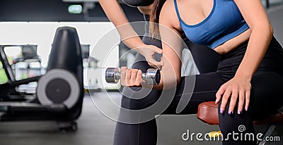 Asian woman exercise and lifestyle at fitness gym. Sporty woman workout with trainer and dumbbell weight. Wellness and healthy Stock Photo