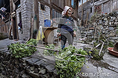 Asian woman farmer Miao people, stands in courtyard peasant house. Editorial Stock Photo