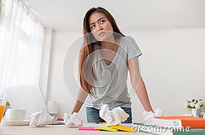 Asian woman freelancer upset with work problem with laptop on mess table.work at home concept.stress working Stock Photo