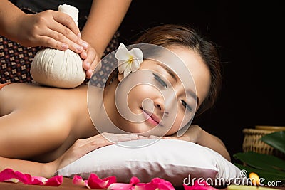 Asian woman getting thai herbal compress massage Stock Photo