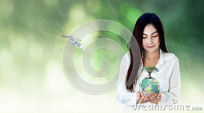 Asian woman hands holding earth globe with big tree Stock Photo