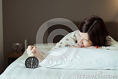 Asian women hates getting stressed waking up early 6 o`clock,Alarm clock,Weekend morning Stock Photo