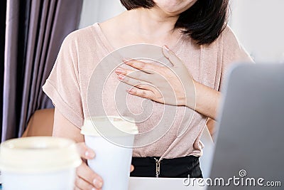 Asian woman having problems with heart palpitations or heart beating too fast after drinking coffee Stock Photo