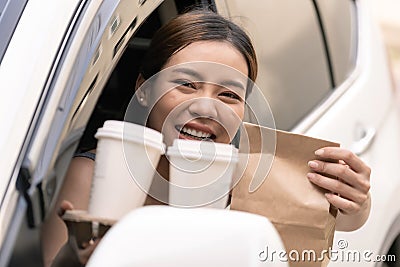 Asian woman holding food bag from drive thru service restaurant Stock Photo