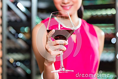 Asian woman holding glass of wine Stock Photo