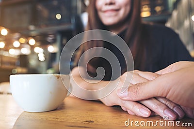 Asian woman holding a man`s hand with feeling love and warmness Stock Photo