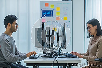 asian woman and Indian man Developer team working about programming software data online at office Stock Photo