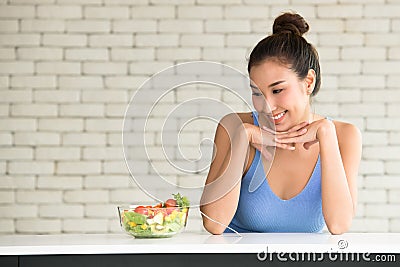 Asian woman in joyful postures with salad bowl on the side Stock Photo