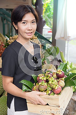 Asian woman with mangosteen fruit basket Stock Photo